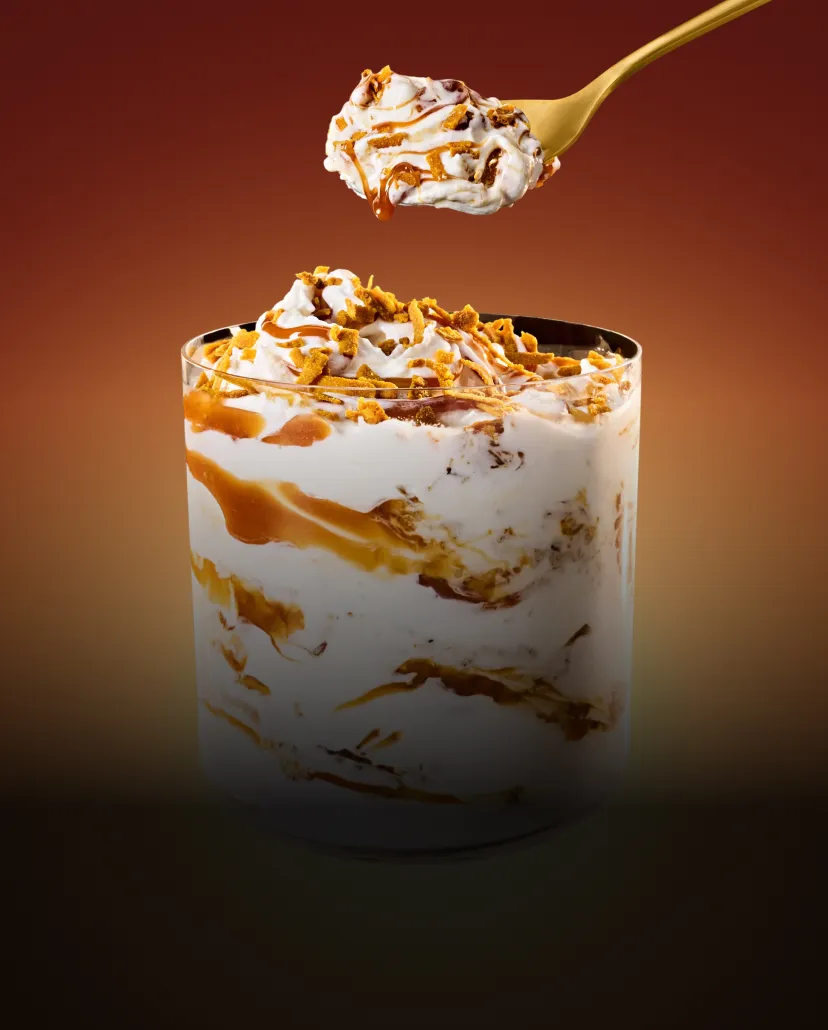 A spoon taking a scoop from a cup of Coconut Caramel McFlurry